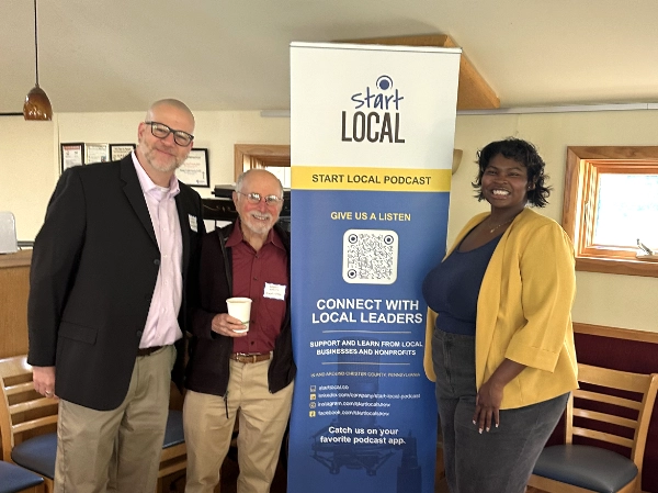 Liam Dempsey, Bob Martin, and Javonna Wylie stand next to the Start Local banner.